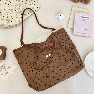 Macro detail of brown corduroy tote bag featuring heart prints and Sweet Candy text