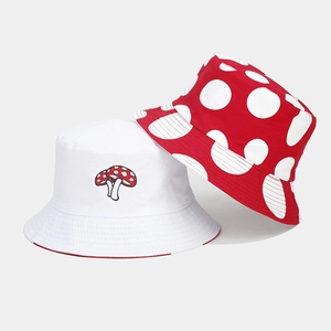 Detail of red and white mushroom embroidery and polka dot patterns on two sun hats