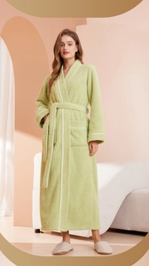 Detail of light green plush bathrobe featuring contrast white trim and large side pockets