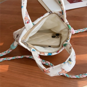 Inside view of quilted cream fabric phone bag with cat print and colorful rope handle