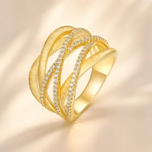 Macro detail of gold-plated S925 silver ring featuring layered crossover bands with moissanite