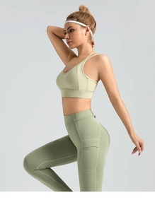 Detail of high-waist sage green yoga leggings with functional side pockets