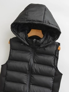 Close-up of quilted black hooded vest with metal zipper and fine stitching detail