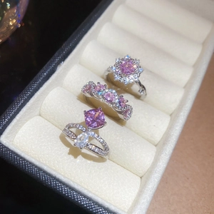 Detailed macro of pink zircon rings in square and floral shapes with polished silver finish