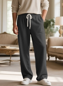 Detail der dunkelgrauen Stricktextur an der locker sitzenden Herren-Freizeithose mit Kordelzug