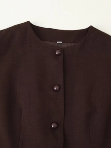 Detailed close-up of dark brown textured fabric with three matching covered buttons