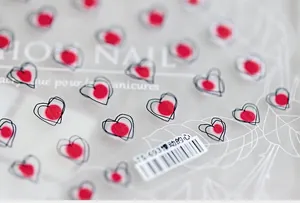 Detail of 5D embossed heart nail stickers with minimalist hand-drawn black line patterns