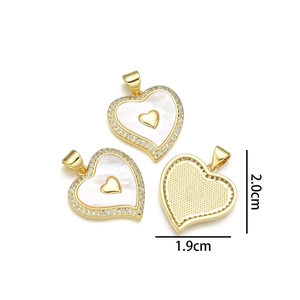 Detailed view of heart pendant with shell inlay and diamonds, dimensions 1.9cm by 2.0cm