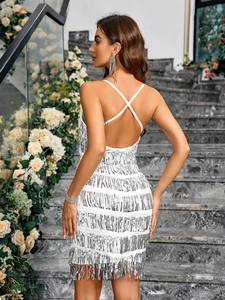 Detail of white sequin dress featuring layered fringes and open back crisscross straps