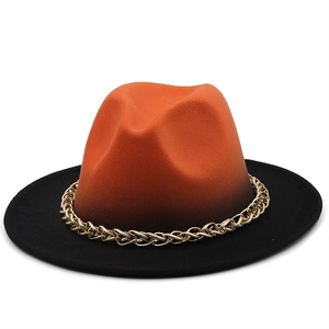 Detail of orange gradient wool fedora hat featuring a stylish gold metal chain band
