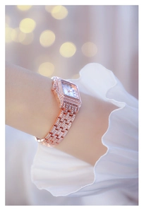 Detail of rose gold square watch featuring Roman numerals and sparkling rhinestones