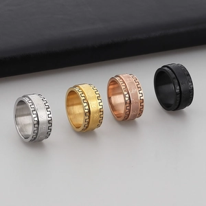 Detail view of four rotating stainless steel rings in silver, gold, rose gold, and black