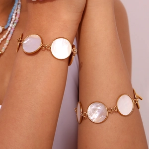 Macro detail of 18K gold-plated OT clasp bracelet with elegant white mother of pearl inlays