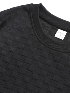 Detail of neckline and waffle textured fabric on men's slim fit black long sleeve top