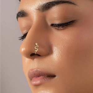 Close-up of a gold snake-shaped S925 silver nose cuff on model with crystal details