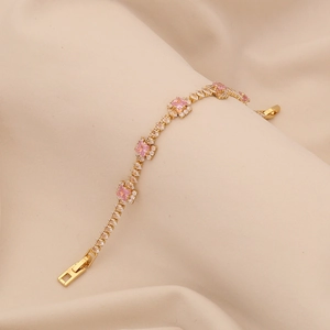 Elegant gold bracelet with pink square zirconia on a minimalist beige satin background