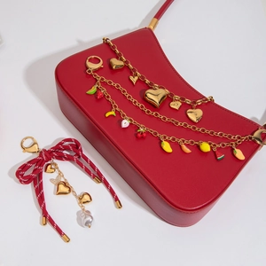 Detailed view of 18K gold heart charms, colorful fruit beads, and pearl bag accessories