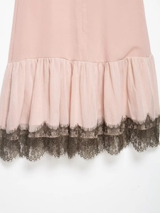 Dettaglio ravvicinato dell'orlo in chiffon rosa chiaro con bordo in pizzo nero a ciglia
