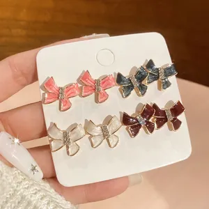 Set of four colorful bow stud earrings with enamel and sparkling diamond centers