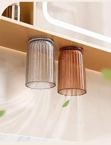 Detail of magnetic upside-down toothbrush cups in grey and amber with vertical stripes