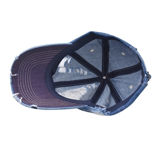 Detailed view of the distressed denim baseball cap showing metal buckle and inner stitching