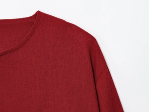 Detailed view of the crew neckline and textured linen-blend fabric on a burgundy jacket