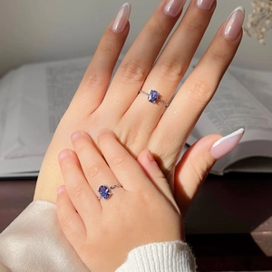 Detail of mother and child wearing silver chain rings with blue oval gemstones