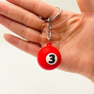 Macro shot of a red number 3 billiards keychain held in hand with metal keyring