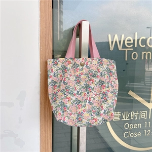 Close-up of floral canvas mini tote bag with pink handles and bronze snap button closure