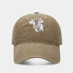 Close-up of vintage washed cotton baseball cap featuring cow embroidery on a curved brim