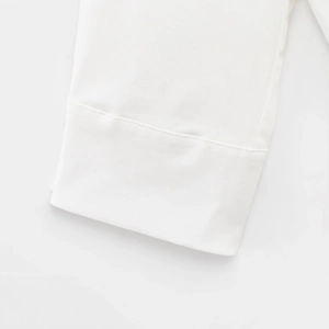 Detailed close-up of white short sleeve romper dress with premium stitching and clean texture