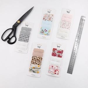 Close-up of 6-piece square floral fabric hair clips set shown with measuring ruler