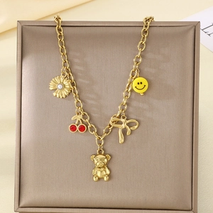 Detail der goldenen Halskette mit Teddybär, Kirsche, Gänseblümchen, Smiley und Schleife