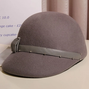 Detail of the grey wool felt hat featuring a leather strap with small rhinestones and a bow