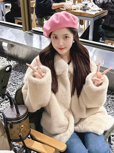 Close-up of bright pink wool beret and thick oatmeal faux fur coat for winter fashion