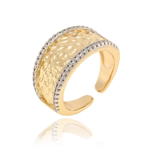 Macro shot of gold wide band ring with hammered texture and silver crystal edges