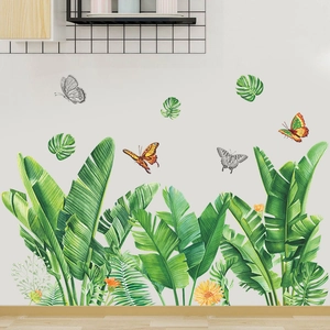 Detail of self-adhesive tropical leaves and butterfly wall stickers on a white wall