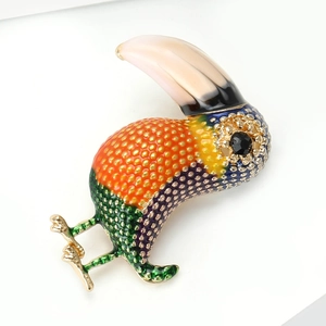 Macro detail of high-end bird brooch with colorful enamel work and gold-tone metal trim