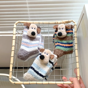Detailed view of thick coral fleece socks with 3D cartoon puppies in a metal basket