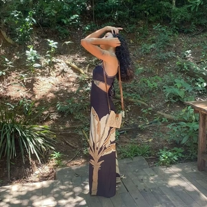 Detail of a tropical leaf print maxi dress featuring an open back and halter neckline style