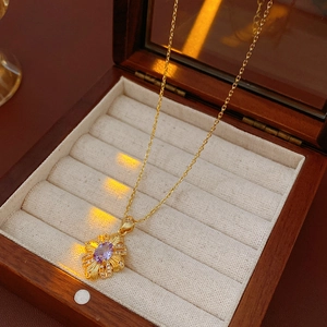Detail of vintage zircon diamond necklace with purple gemstone in a brown wooden jewelry box