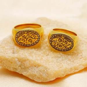 Macro view of vintage gold rings with floral engraving and zircon stones on stone
