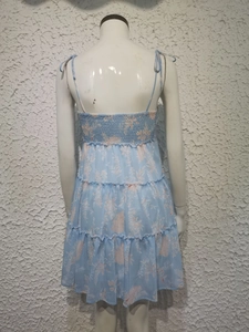 Close-up of smocked back detail on light blue floral summer dress with tiered hem