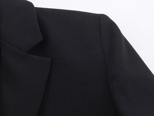 Close-up of the black lace suit dress showing refined shoulder and collar fabric details