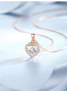 Macro detail of rose gold heart pendant with dancing center stone and pavé setting