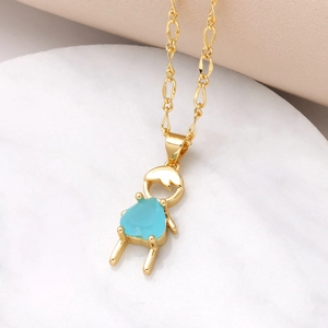 Gold pendant necklace with blue gemstone boy charm on white marble background