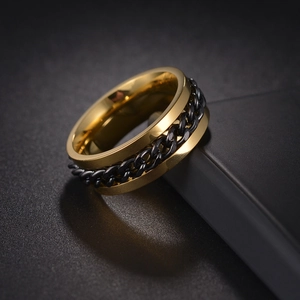 Macro shot of gold and black spinning chain ring on display box edge with metal texture
