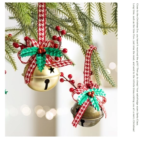 Close-up of Christmas bell ornaments with red plaid bows and green leaves on pine branches