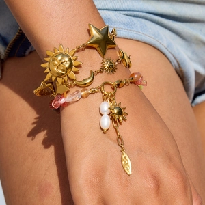 Gold celestial star and moon bracelets with pink natural stones and pearls on wrist