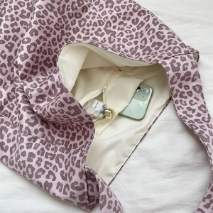 Interior detail of large leopard print tote bag showing zipper pocket and lining